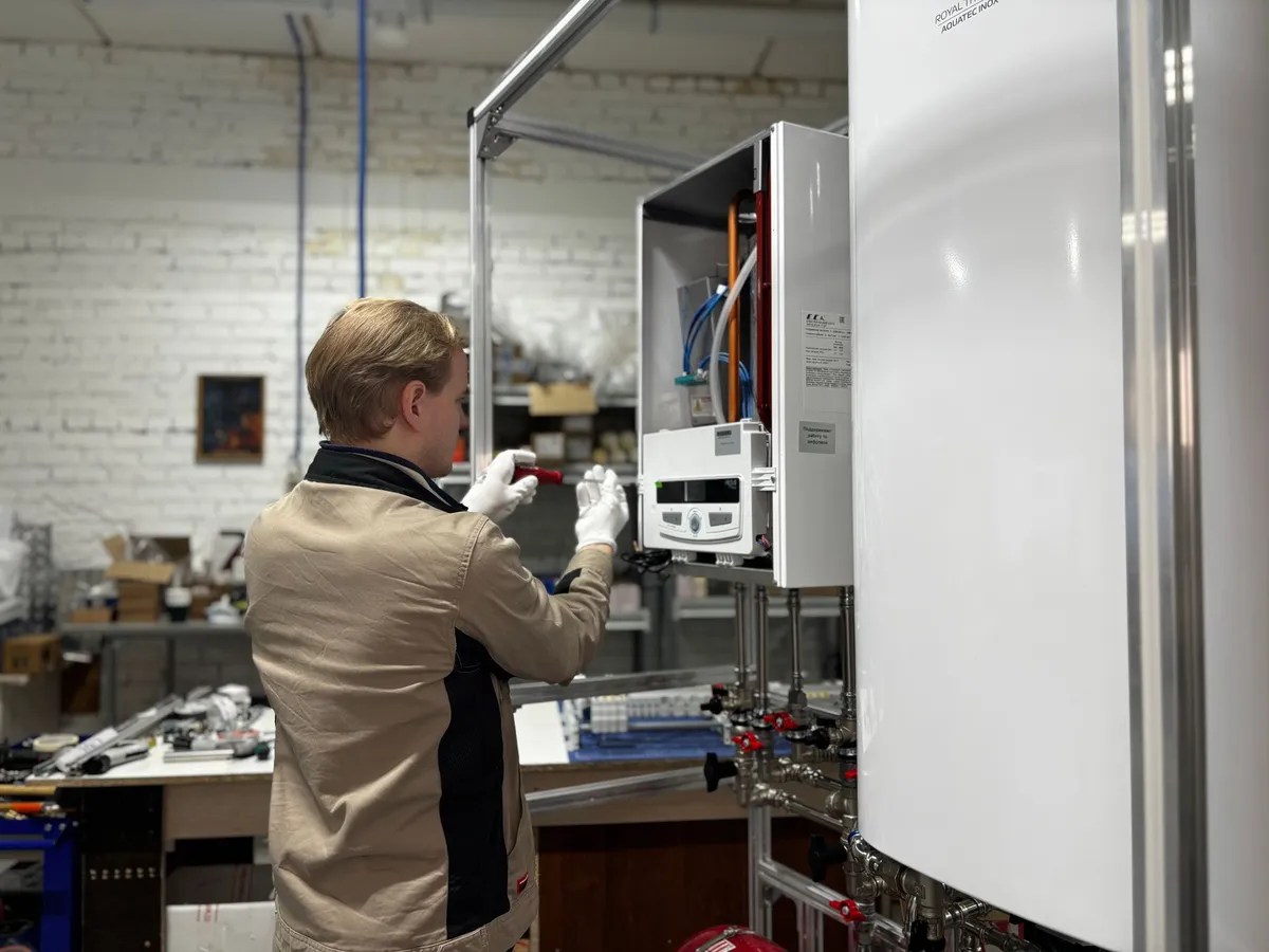 Technician servicing a wall-mounted boiler