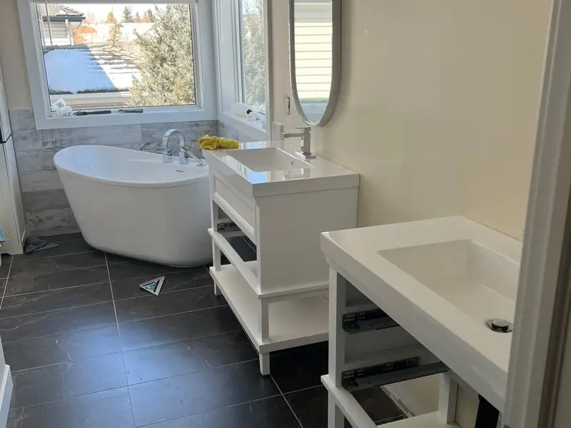 Renovated ensuite bathroom with freestanding soaker tub and dual vanities plumbed in Auburn Bay, SE Calgary
