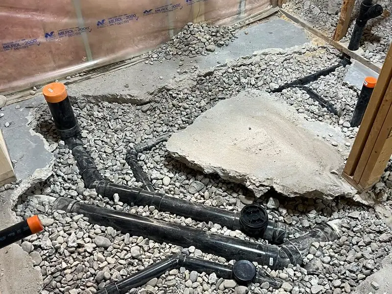 Underground drain and sewer line repair with new ABS piping beneath a Somerset, SW Calgary basement floor