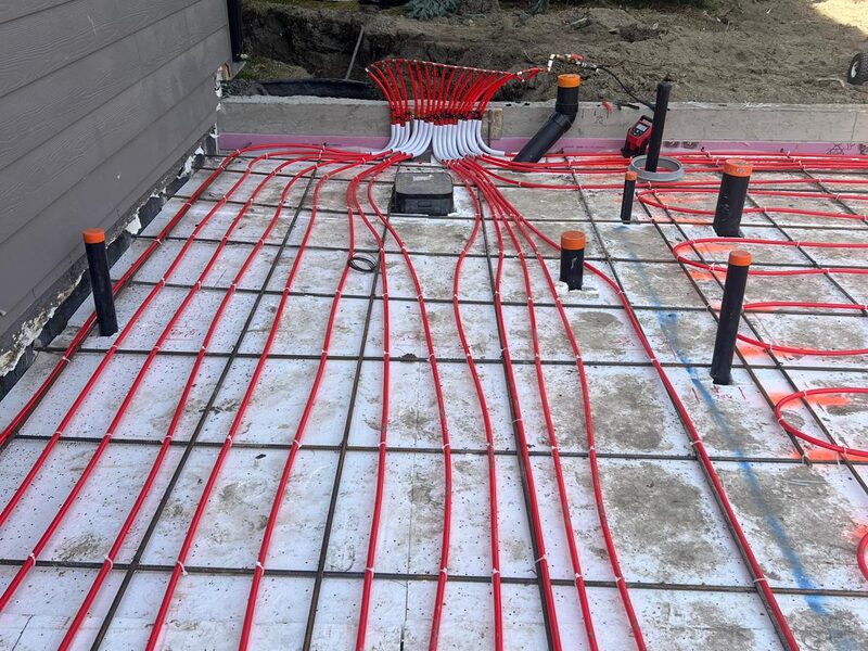 In-floor radiant heating PEX tubing laid over a reinforced slab in Mount Douglas, SE Calgary