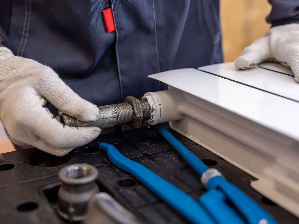 Licensed technician assembling a radiator pipe fitting